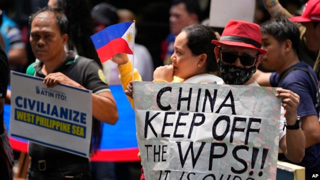 菲律宾渔民和活动人士在中国驻马卡蒂领事馆前举牌抗议中国海警执法新规。(2024年6月11日)